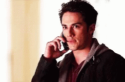 A Man In A Black Jacket Is Talking On His Cell Phone GIF