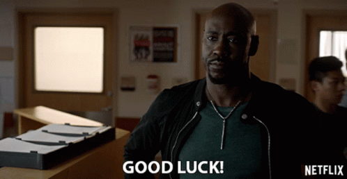 A Man In A Black Jacket Says Good Luck In Front Of A Netflix Logo GIF