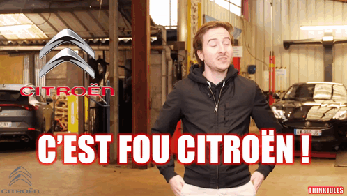 A Man In A Black Jacket Stands In Front Of A Citroen Logo GIF
