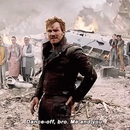A Man In A Black Jacket Stands In Front Of A Group Of People And Says " Dance Off Bro Me And You " GIF