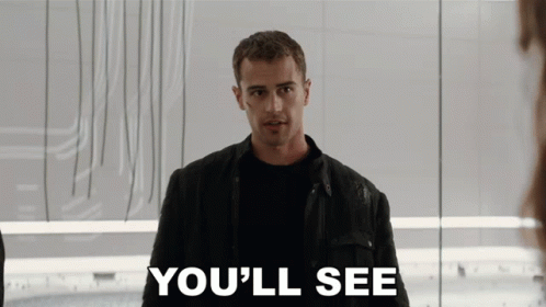 A Man In A Black Jacket Stands In Front Of A Sign That Says " You 'Ll See " GIF