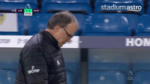 A Man In A Black Jacket Stands In Front Of Stadium Astro GIF