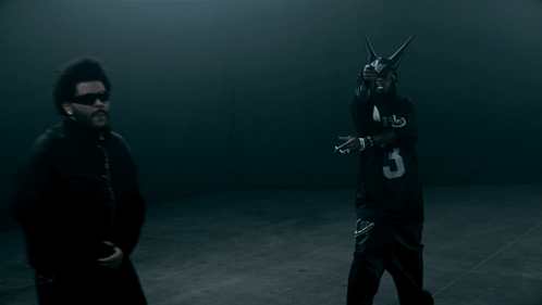 A Man In A Black Jersey With The Number 3 On It Stands Next To Another Man GIF