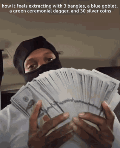 A Man In A Black Mask Is Holding A Stack Of Money And A Green Ceremonial Dagger GIF
