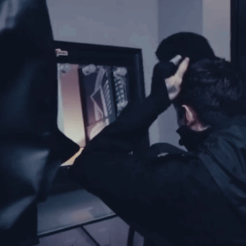A Man In A Black Mask Is Looking At A Screen With A Sticker On It That Says ' X Ray ' GIF