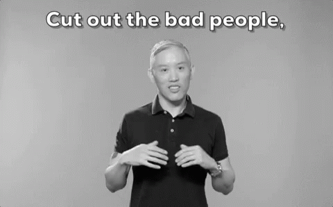 A Man In A Black Polo Shirt Is Standing In Front Of A Gray Background . GIF