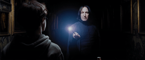 A Man In A Black Robe Is Pointing At Another Man GIF
