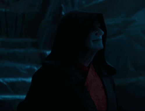 A Man In A Black Robe With A Hood And Red Eyes GIF