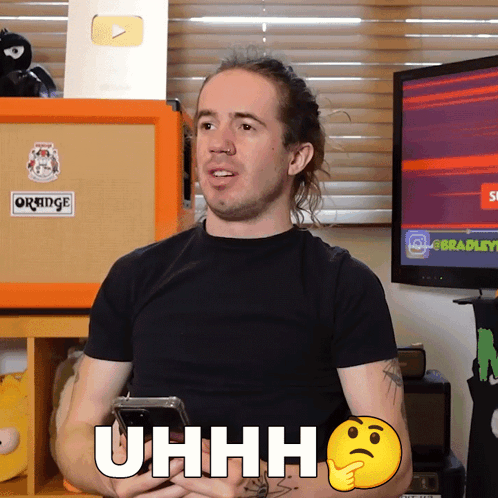 A Man In A Black Shirt Holds A Cell Phone And Says Uhh GIF