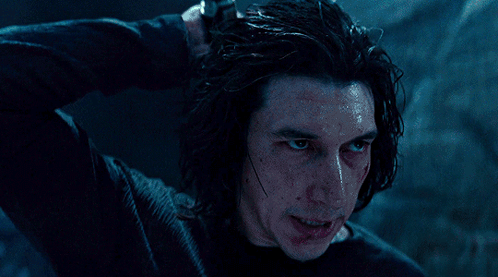 A Man In A Black Shirt Holds A Light Saber GIF