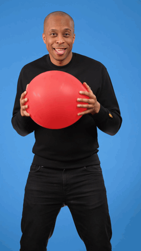 A Man In A Black Shirt Holds A Red Balloon In His Hands GIF