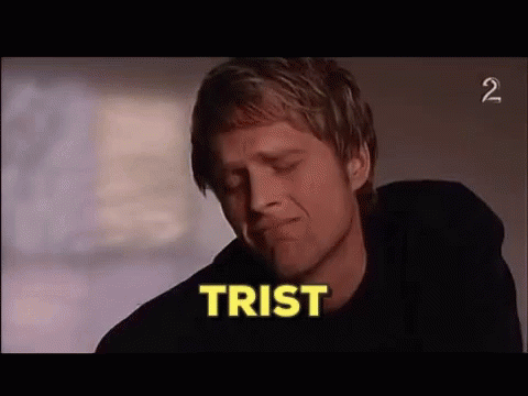 A Man In A Black Shirt Is Crying With The Word Trist In The Background . GIF