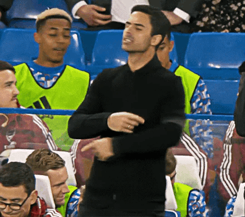 A Man In A Black Shirt Is Dancing In A Crowd GIF