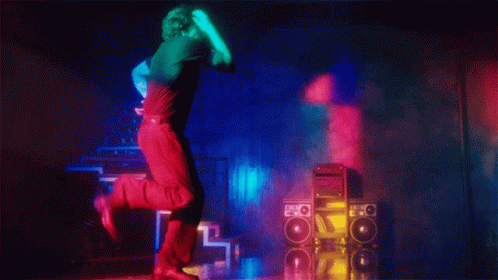 A Man In A Black Shirt Is Dancing In Front Of A Stack Of Speakers With The Letter O On Them GIF