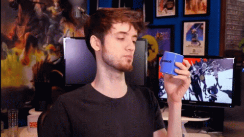 A Man In A Black Shirt Is Holding A Blue Microsoft Box GIF
