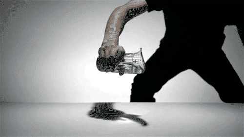 A Man In A Black Shirt Is Holding A Glass With The Word Coca Cola On It GIF