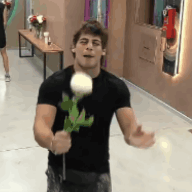 a man in a black shirt is holding a rose in his hands .
