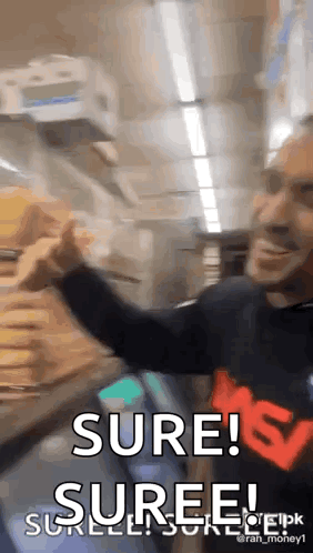 A Man In A Black Shirt Is Holding A Stack Of Money And Says Sure ! Suree ! GIF
