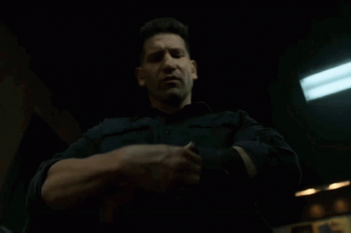 A Man In A Black Shirt Is Holding Something In His Hands GIF