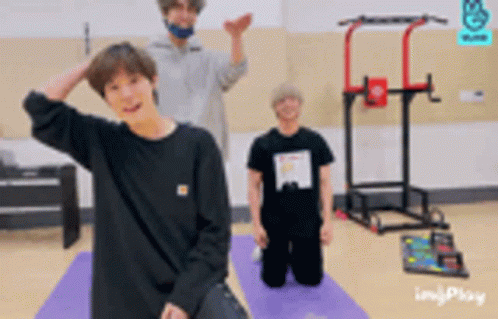 A Man In A Black Shirt Is Kneeling Down On A Yoga Mat GIF