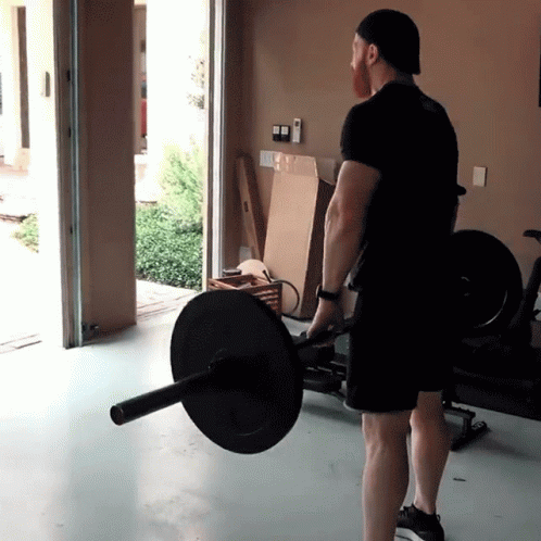 A Man In A Black Shirt Is Lifting A Barbell GIF