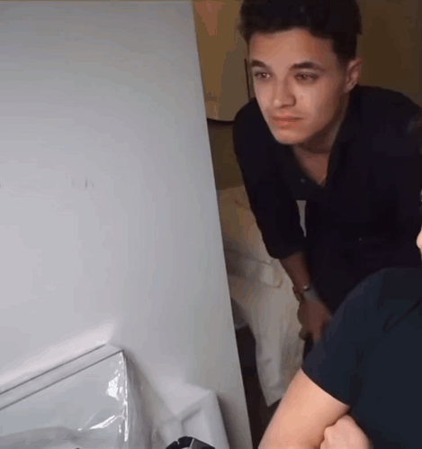 A Man In A Black Shirt Is Looking At Something GIF