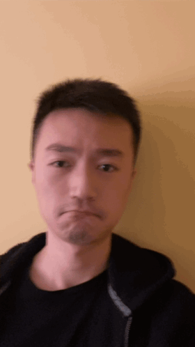 A Man In A Black Shirt Is Making A Face GIF