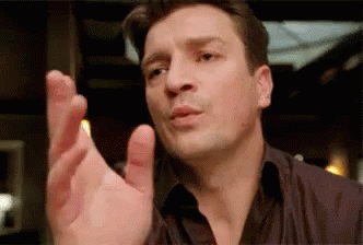 A Man In A Black Shirt Is Making A Funny Face And Pointing His Finger . GIF