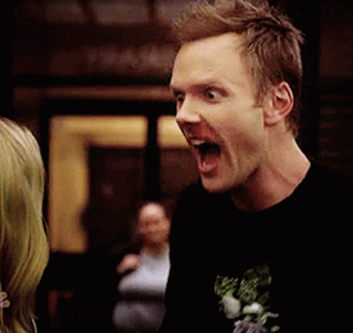 A Man In A Black Shirt Is Making A Funny Face With His Mouth Wide Open GIF