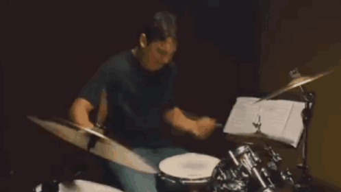 A Man In A Black Shirt Is Playing Drums GIF