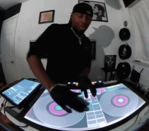 A Man In A Black Shirt Is Playing Music On A Turntable GIF