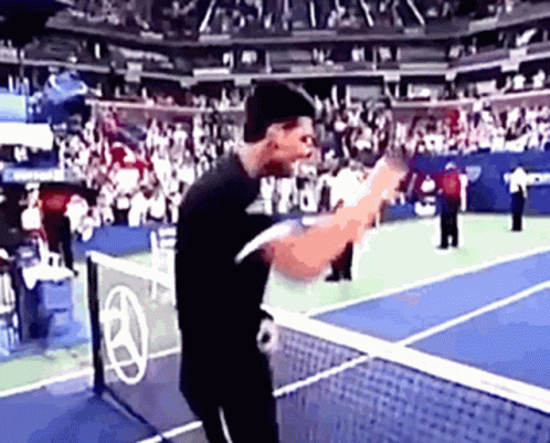 A Man In A Black Shirt Is Playing Tennis GIF