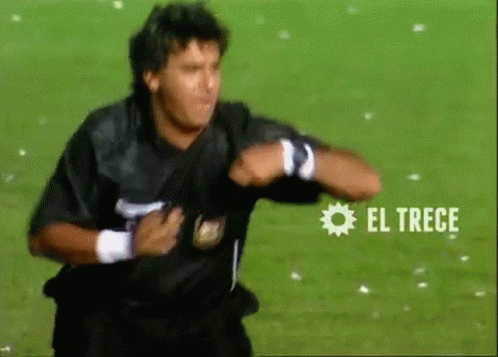 A Man In A Black Shirt Is Running On A Soccer Field With El Trece Written On The Bottom GIF