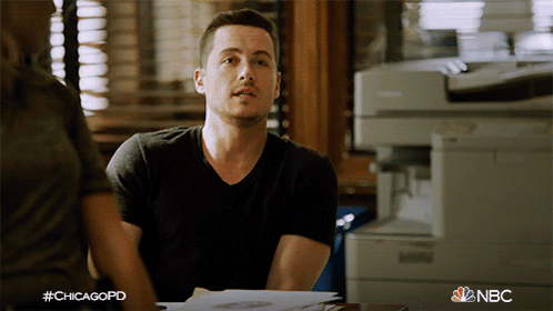 a man in a black shirt is sitting at a desk with a nbc logo in the corner
