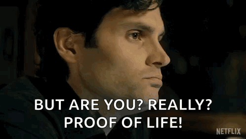 A Man In A Black Shirt Is Sitting In A Room And Says `` But Are You Really ? Proof Of Life ! '' GIF