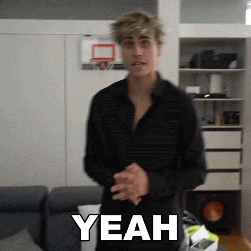 A Man In A Black Shirt Is Standing In Front Of A Basketball Hoop And Says Yeah GIF
