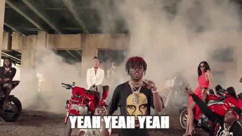 A Man In A Black Shirt Is Standing In Front Of A Group Of People On Motorcycles . GIF