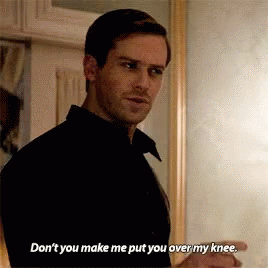 A Man In A Black Shirt Is Standing In Front Of A Mirror And Talking To Someone . GIF