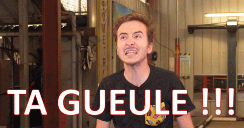 A Man In A Black Shirt Is Standing In Front Of A Sign That Says Ta Gueule GIF