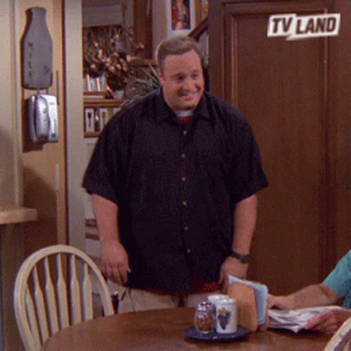 A Man In A Black Shirt Is Standing In Front Of A Tv Land Sign GIF