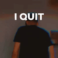 A Man In A Black Shirt Is Standing In Front Of A Wall With The Words `` I Quit '' On It . GIF