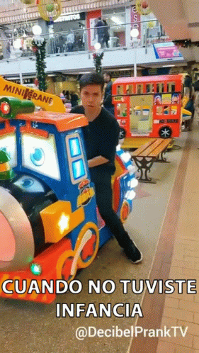 A Man In A Black Shirt Is Standing Next To A Toy Train With The Words " Cuando No Tuviste Infancia " On It GIF