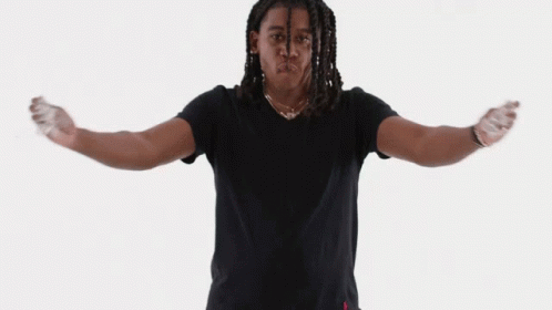 A Man In A Black Shirt Is Standing With His Arms Outstretched In Front Of A White Background GIF