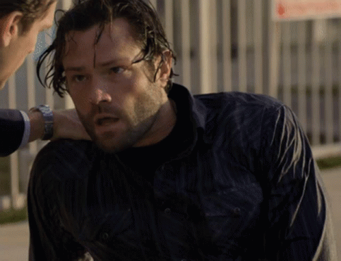 a man in a black shirt is talking to another man