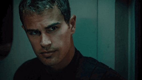 A Man In A Black Shirt Looks At The Camera GIF