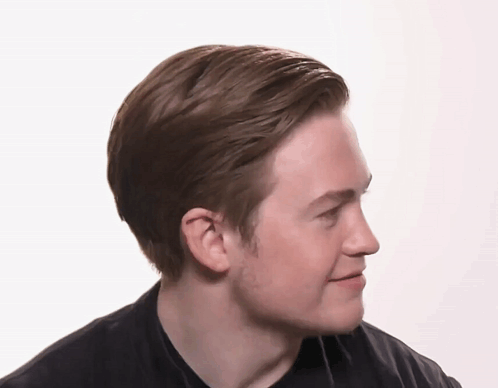 A Man In A Black Shirt Looks To His Left GIF