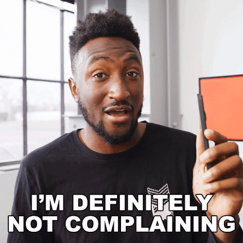 A Man In A Black Shirt Says " I 'M Definitely Not Complaining " While Holding A Cell Phone GIF