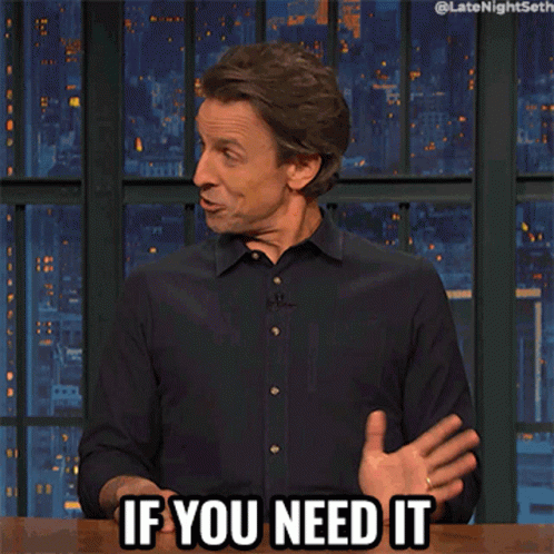 A Man In A Black Shirt Says " If You Need It " With His Hand On His Chest GIF