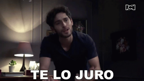 A Man In A Black Shirt Says Te Lo Juro In A Dark Room GIF