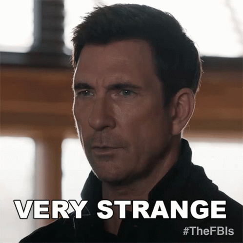 A Man In A Black Shirt Says Very Strange On The Bottom GIF